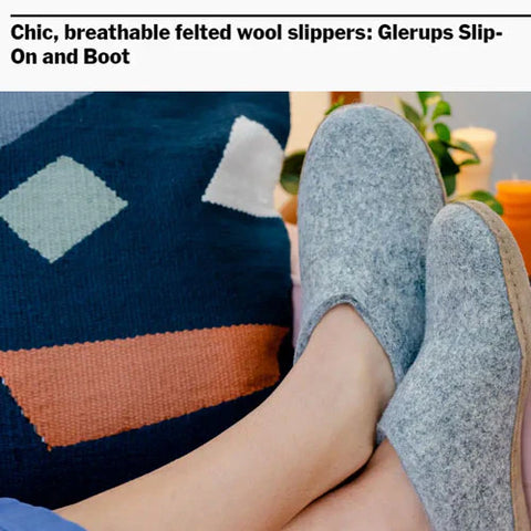 A person is wearing Grey glerups slip-ons with leather soles while sitting indoors, with legs resting on a surface.